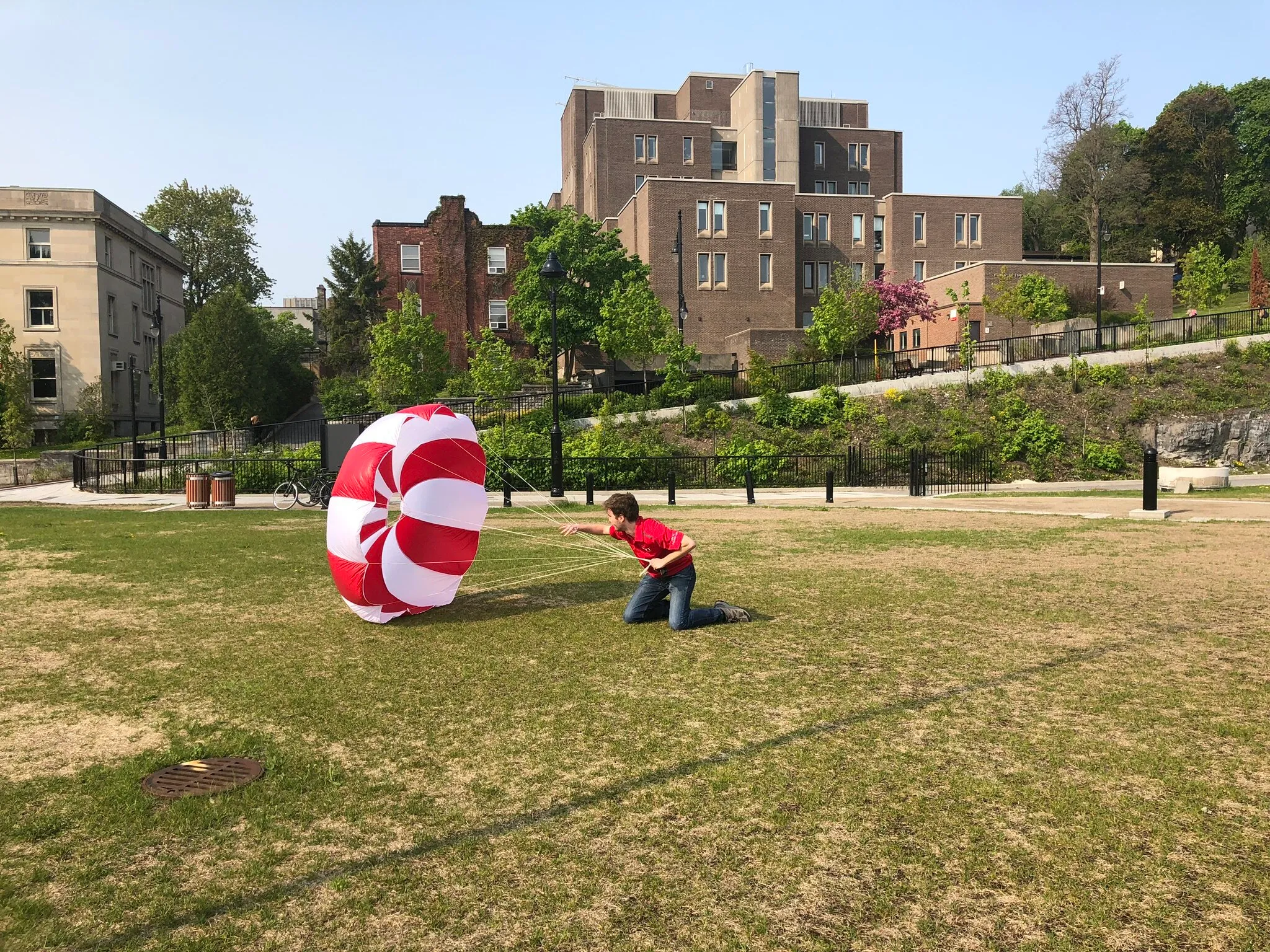 A person testing a parachute on a field.